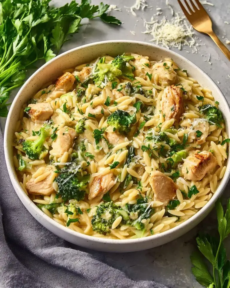 Cheesy chicken broccoli orzo dish served in a bowl with fresh ingredients