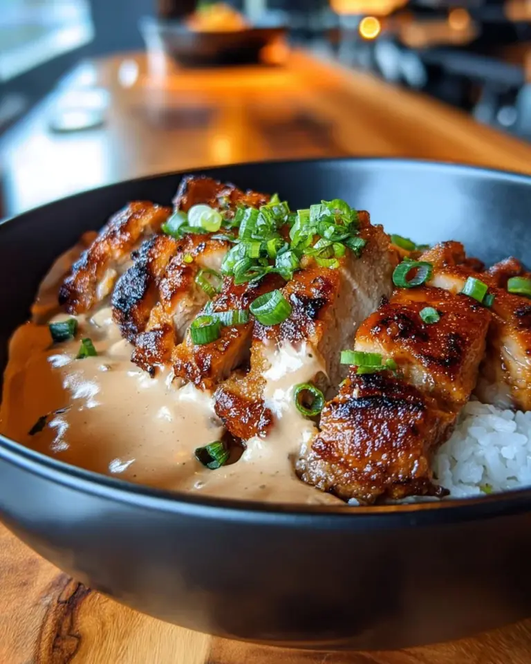 Chicken rice bowl with creamy garlic sauce garnished with herbs