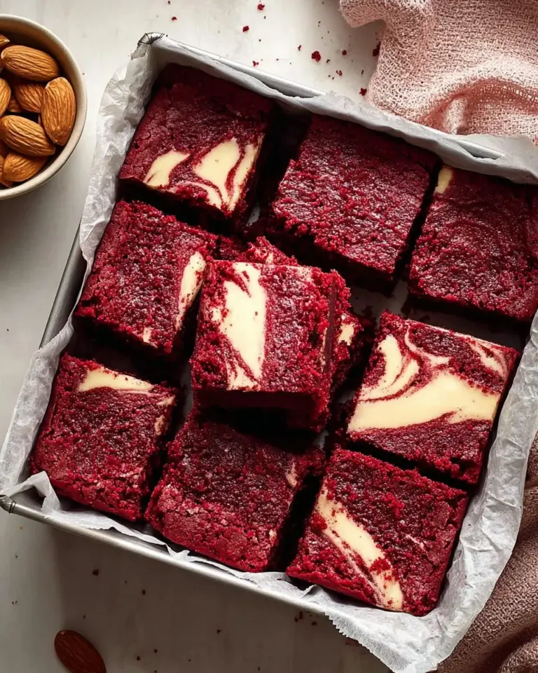 Gluten free red velvet brownies made with almond flour and topped with cream.