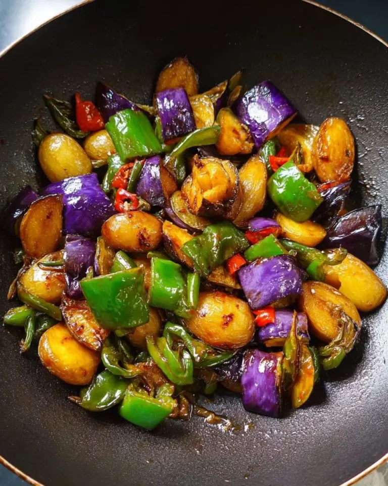 Northeastern stir-fried eggplant with potatoes and bell peppers in a colorful dish.