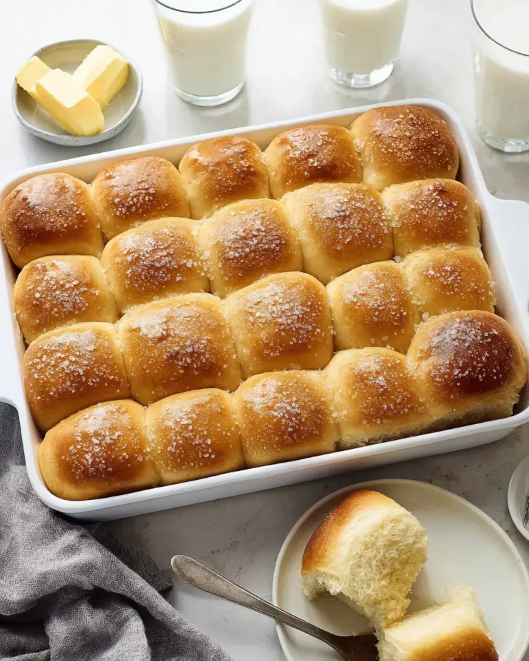 Freshly baked Parker House Rolls on a wooden table.