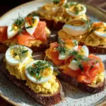 Smoked salmon crostini garnished with egg-cheddar mousse on a wooden platter